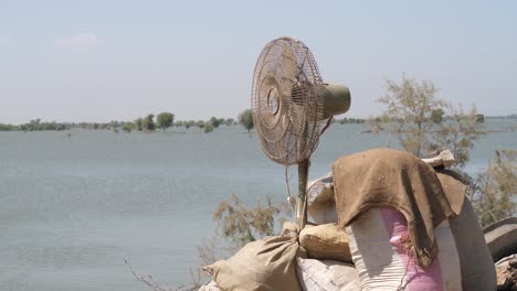 View-Of-Old-Pedestal-Fan-Beside-Sacks-In-Maher,-Sindh