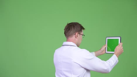 back view of man doctor using digital tablet with chroma key green screen