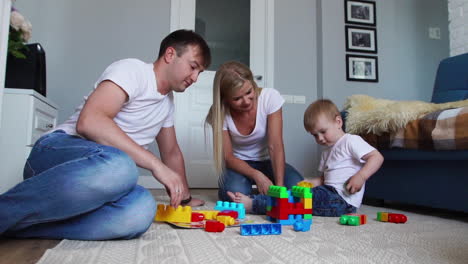 Glückliche-Familie,-Vater,-Mutter-Und-Baby-2-Jahre,-Die-In-Ihrem-Hellen-Wohnzimmer-Lego-Spielen.-Zeitlupenaufnahmen-Einer-Glücklichen-Familie