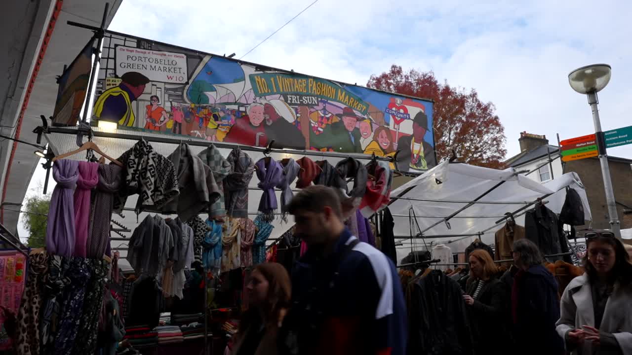 People browsing colorful clothes at Portobello Green Vintage Market on Portobello Road, London