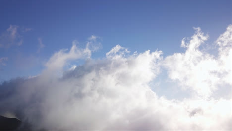 Stratus-clouds-rise-and-glow-from-sunlight-under-blue-sky-up-in-the-heavens