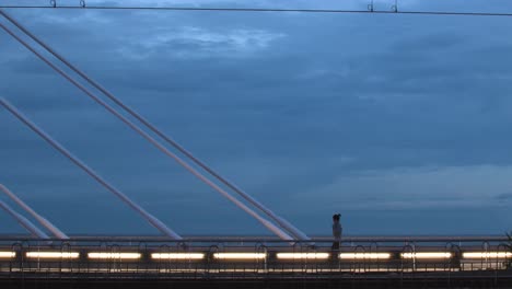 Girl-crosses-the-illuminated-bridge-of-Calella-at-night