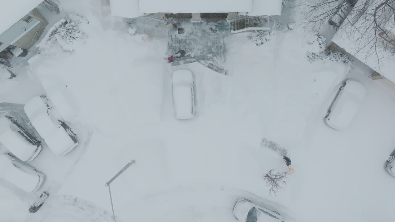 Aerial view of cars and homes covered in snow, peaceful winter scene