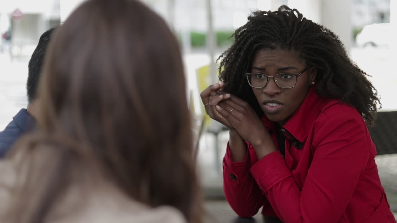 Serious woman talking to young couple, looking disappointed