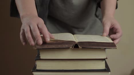 mirando a través de una vieja pila de libros