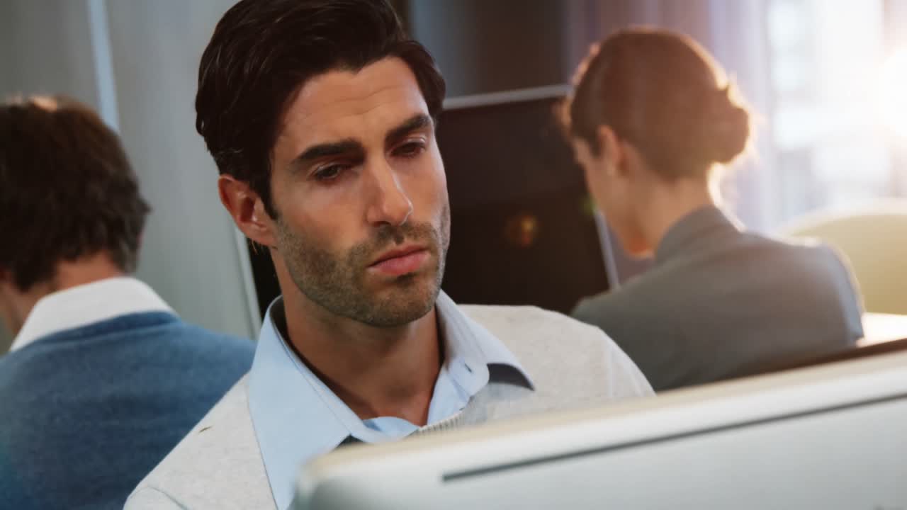 ejecutivo de negocios masculino trabajando en la computadora con compañeros de trabajo