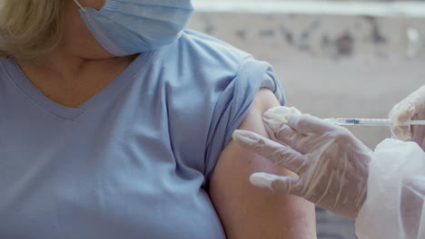 médicos insertando una jeringa con inyección en el brazo de la mujer
