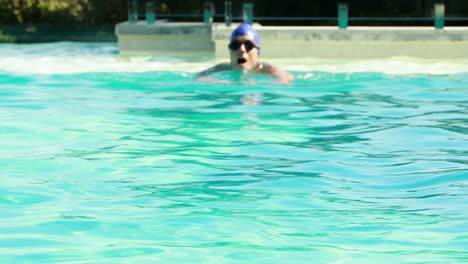 fit man swimming in outdoor pool