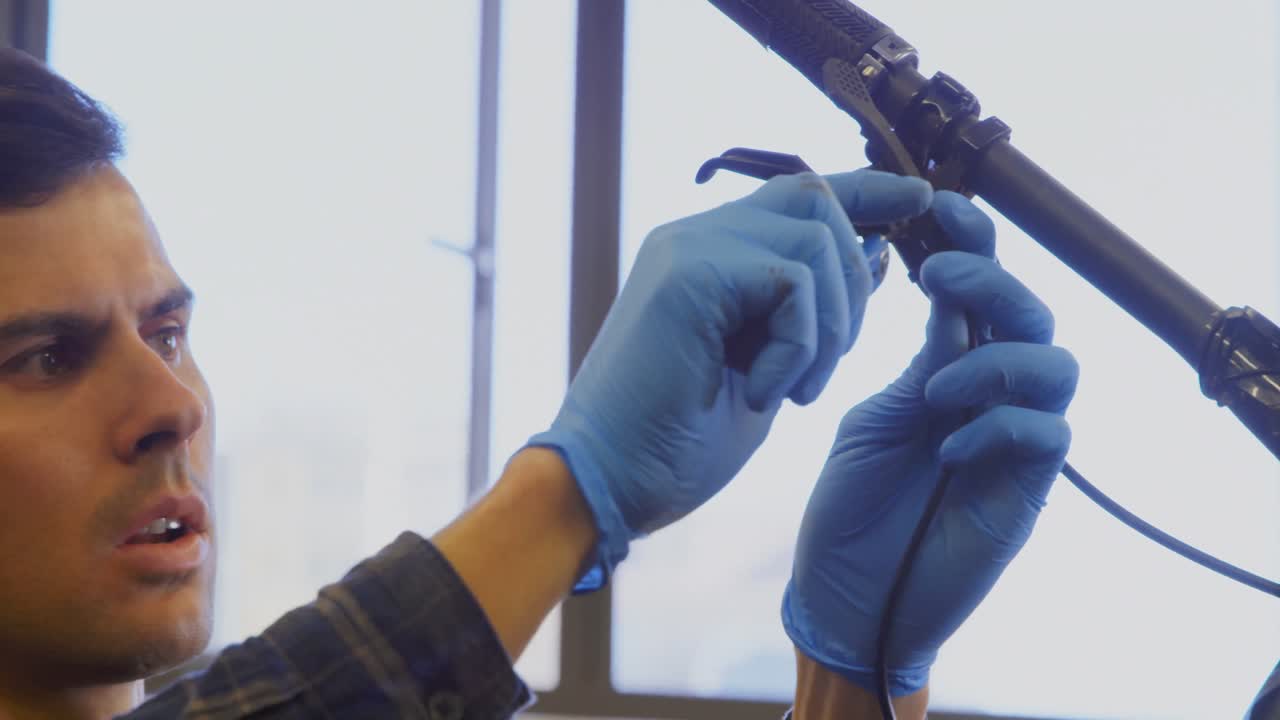 hombre reparando una bicicleta en el taller 4k