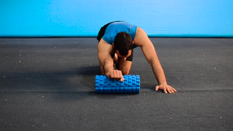 a hand held shot of a guy using a massage roller with only his bodyweight