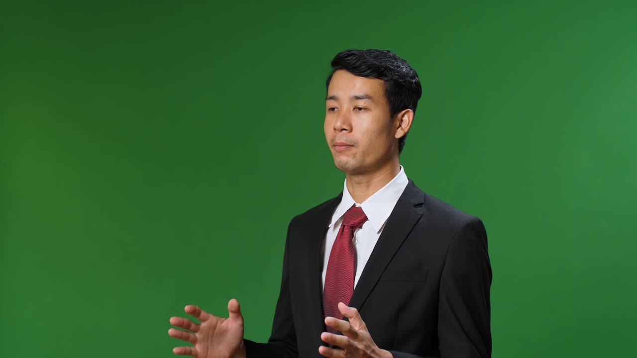 Young Asian Businessman In Suit Jacket Standing And Presenting Something On Green Screen Background, Chroma Key