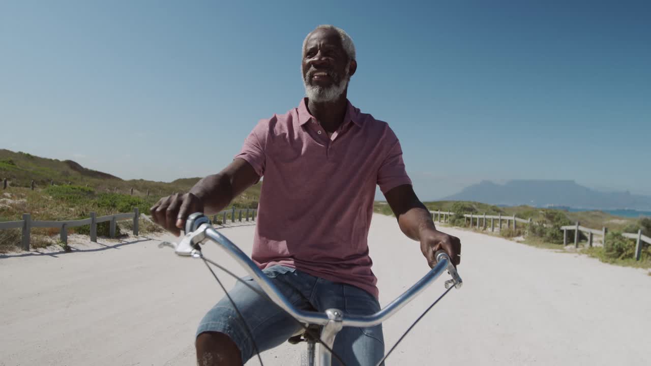 Anziano in bicicletta vicino alla spiaggia