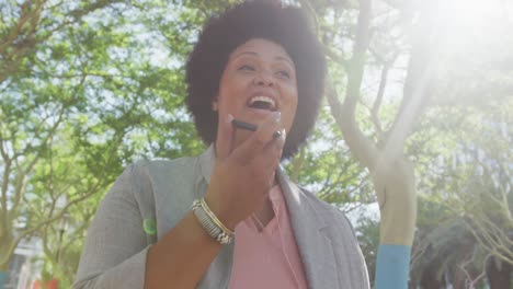 Feliz-Mujer-Birracial-De-Talla-Grande-Hablando-Por-Teléfono-Inteligente-En-El-Parque