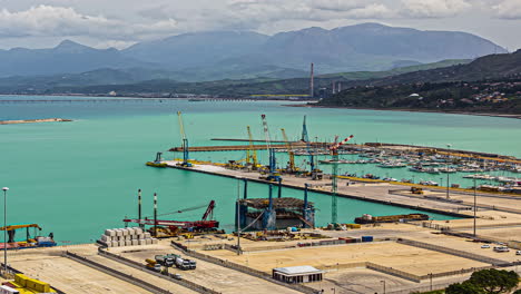 puerto de sicilia con pórticos de grúas y un timelapse de barco