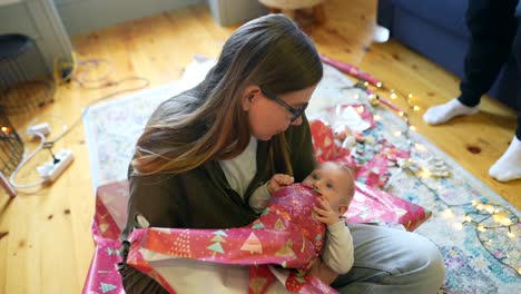madre y bebé desempaquetando regalos de navidad