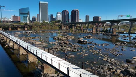 James-River-and-pedestrian-bridge-with-Richmond,-Virginia-skyline-on-bright-autumn-day