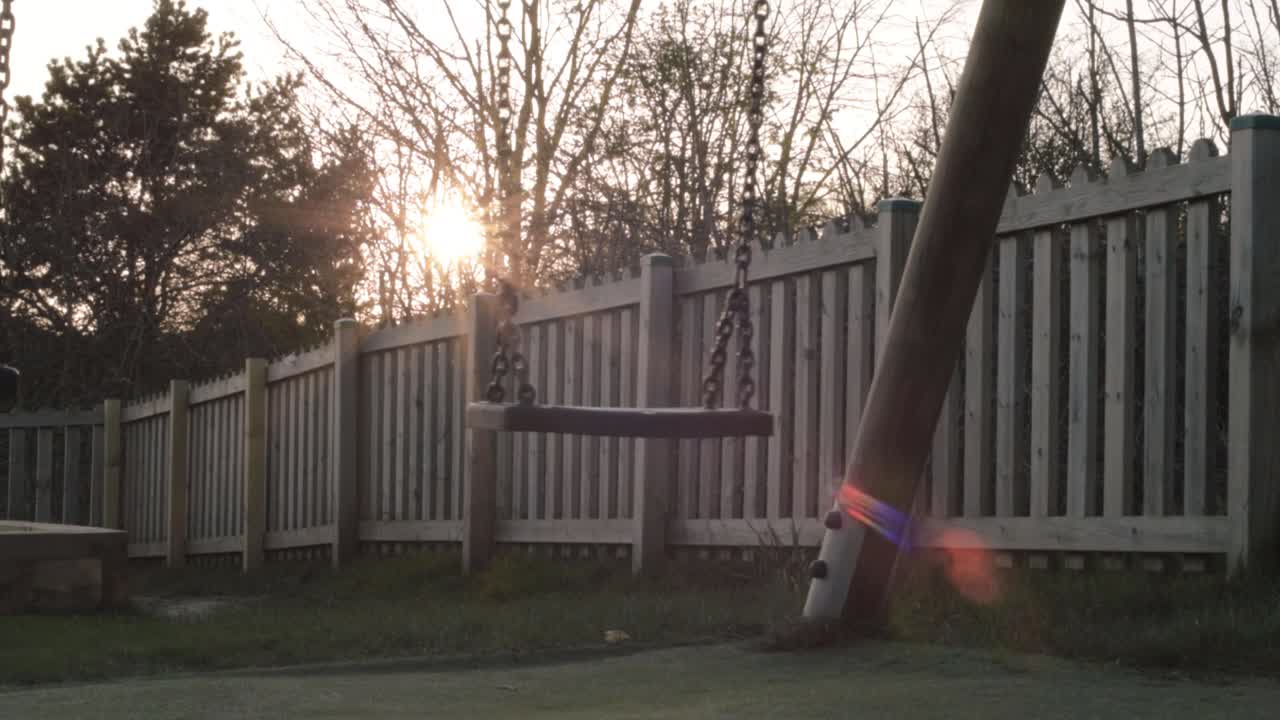 Swing set in a park at sunset