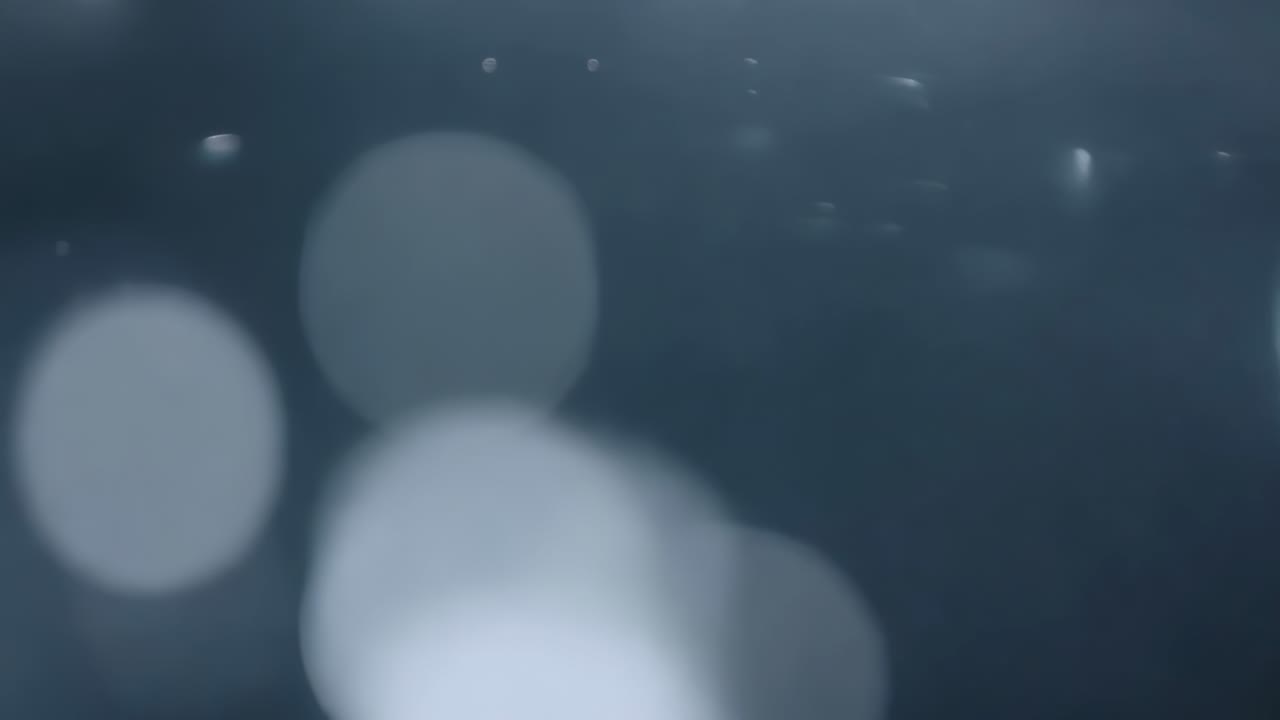 Starting sequence showing cluster of blurred bokeh discs drifting toward center, with bright specks