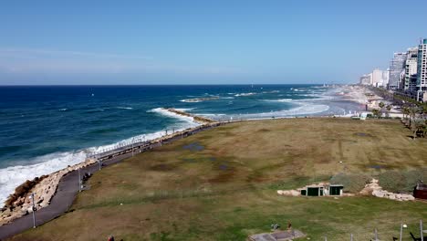 toma aérea de un dron giratorio de un parque vacío cerca de la ciudad y el mar