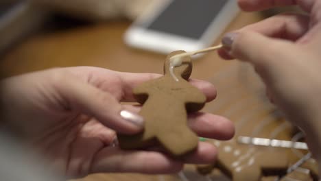 close-up shot of a lady putting icing on a gingerbread man