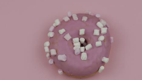 sweet donut rotating on pink background. top view. tasty, fresh donut