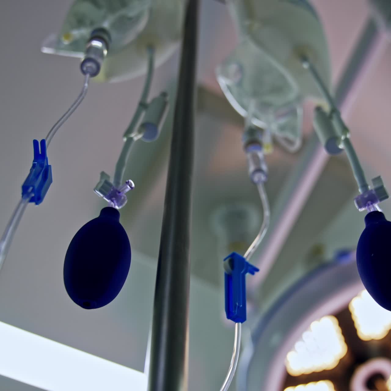 Plastic bags filled with medicines hanging from the drop counter stand. Tubes and enema pears. Low angle view