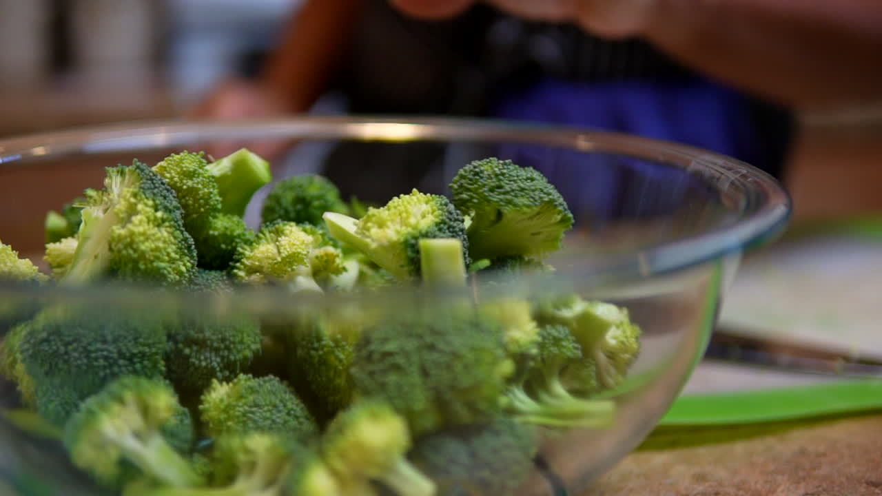 Preparing a bowl of broccoli for a meal or snack - slow motion isolated