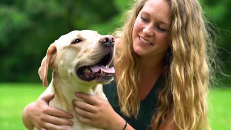 young woman affectionately hugging labrador dog