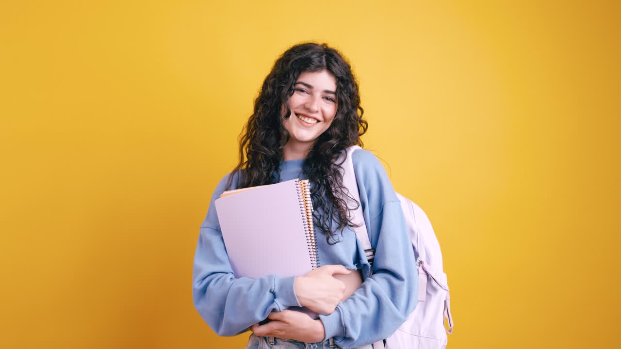 Smiling student with notebooks and backpack
