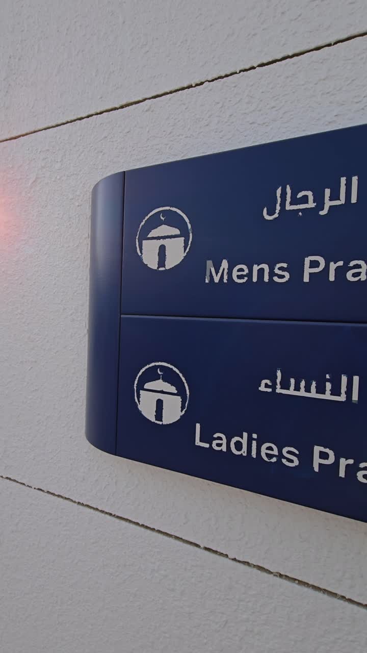 Male and female prayer room signs displayed outside the rest area of a petrol station in the UAE
