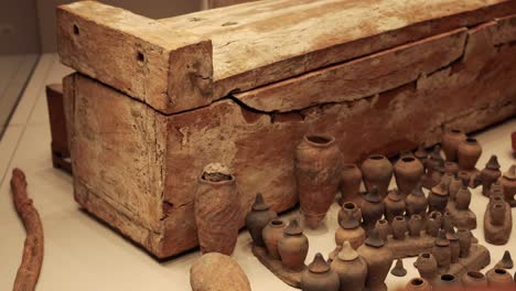 wooden coffin surrounded by historical pottery artifacts