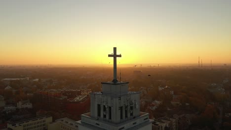 Drone-aerial-view-of-flying-birds-near-church-in-Kaunas,-Lithuania