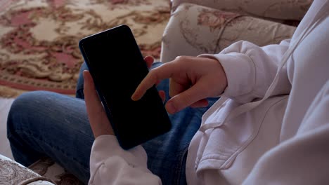 십대는 스마트 폰에서 정보를보고 있습니다. 알파 채널이 포함되어 있습니다. 스마트 폰 화면에 비디오를 입 할 수 있습니다.
