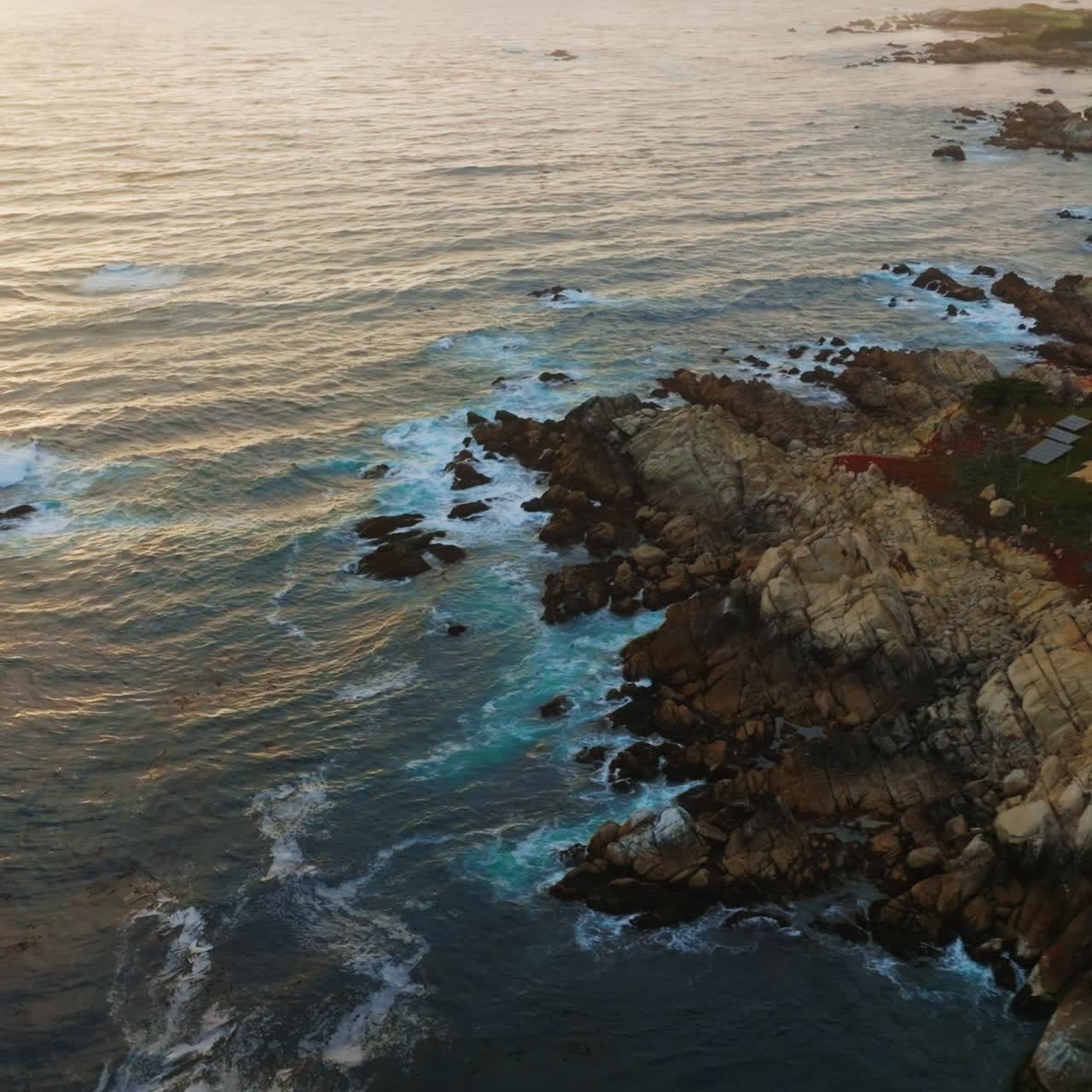 Costa frastagliata con case costruite tra gli alberi. Splendido litorale dell'Oceano Pacifico con onde che si infrangono. Tramonto sull'oceano