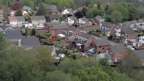 quiet british homes and gardens residential suburban property aerial view dolly left above trees