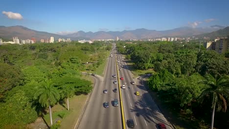 aerial shot of a highway in valencia, carabobo, venezuela, next to a green park