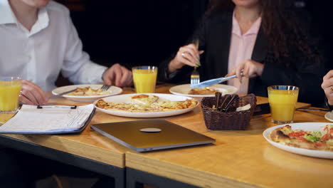 business people eating pizza during the lunchtime. colleagues having meals and discussing working issues.