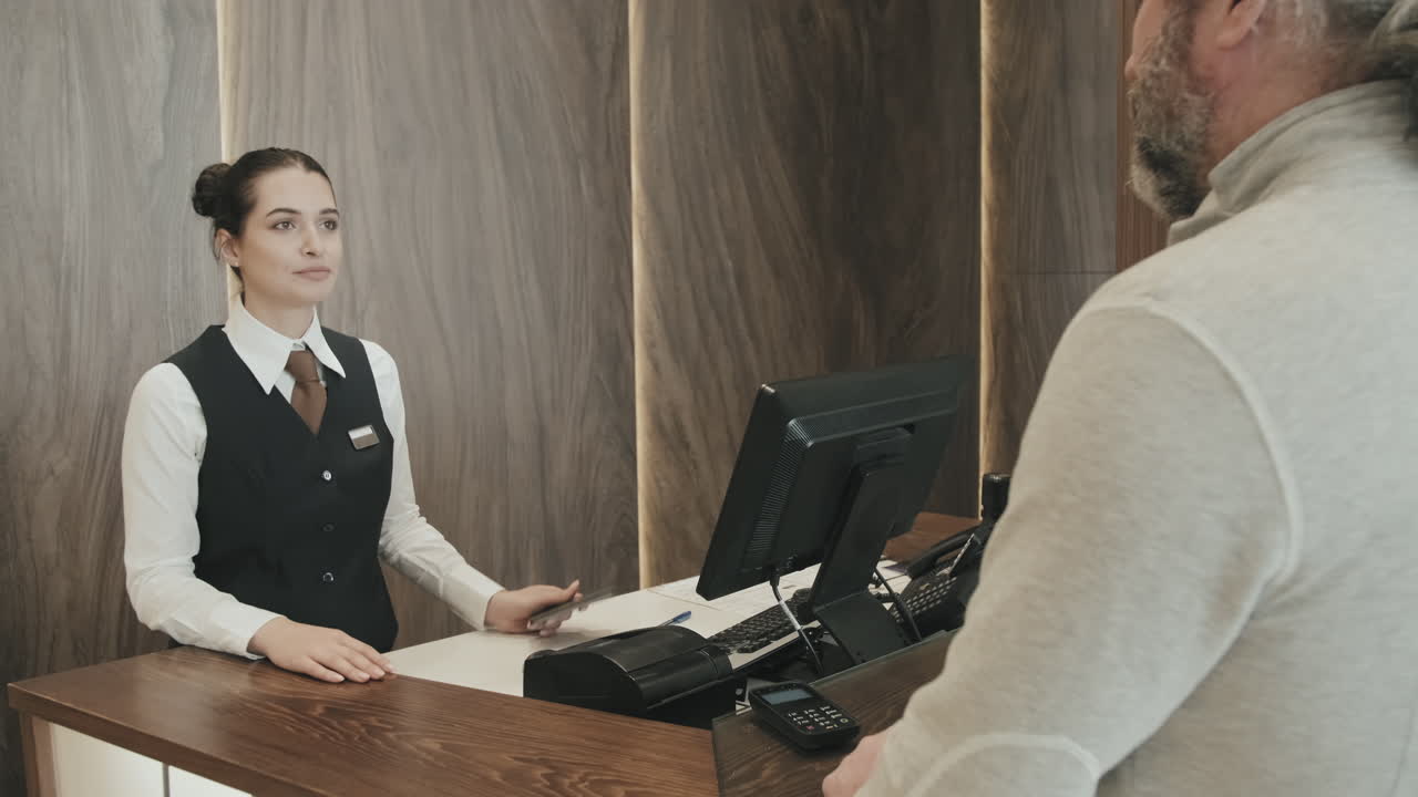 Businessman Paying for Hotel at Reception Desk