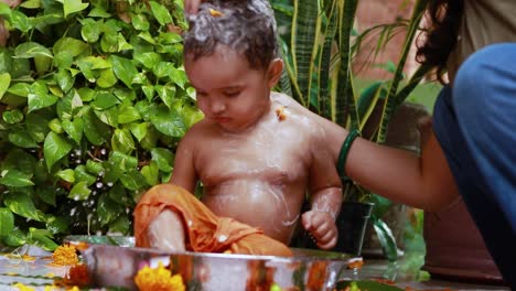 cute toddler baby boy bathing with soap in decorated bathtub at outdoor from unique perspective