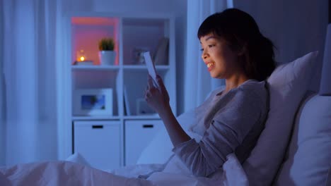 Mujer-Con-Teléfono-En-La-Cama-Haciendo-Una-Videollamada-Por-La-Noche.-Concepto-De-Tecnología,-Internet-Y-Personas.-Mujer-Asiática-Joven-Con-Teléfono-Inteligente-Haciendo-Una-Videollamada-Acostada-En-La-Cama-En-Su-Casa-Por-La-Noche.