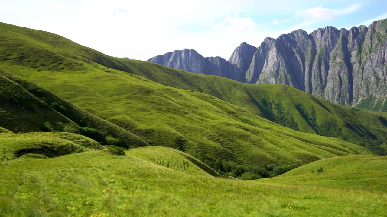 aerial view of serene green hills and mountains in a natural outdoor setting with grass and rocks, tranquil beauty in nature documentaries and travel videos, aerial view of tranquil beauty.