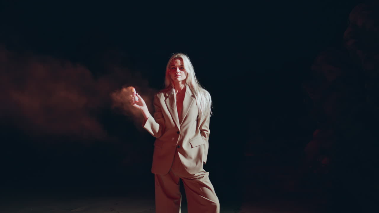 chica sexy sosteniendo una bomba de humo en un traje de moda. mujer segura de sí misma protestando posando