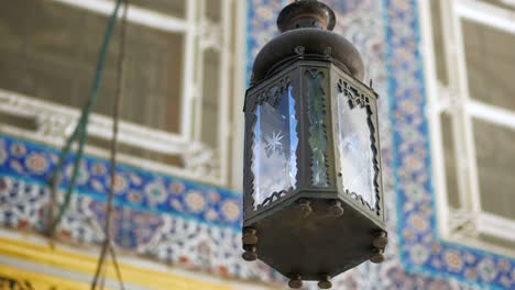 close-up of an ornate metal lantern hanging from a ceiling