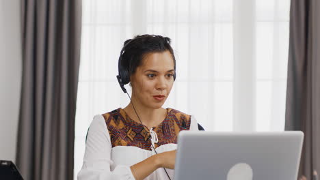 mujer emocionada con auriculares durante una llamada de video