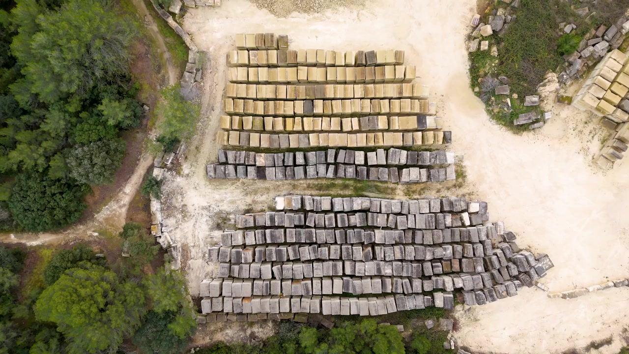Aerial view of large stone blocks stacked in rows at an outdoor quarry site