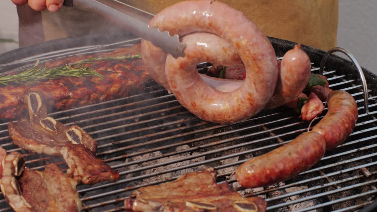 Traditional spanish barbeque, big sausage chorizo botifarra, pork and beef ribs on grill with fire, american style cooking, chef grilling meat fat food, steaks and sausages on bbq. High quality 4k footage