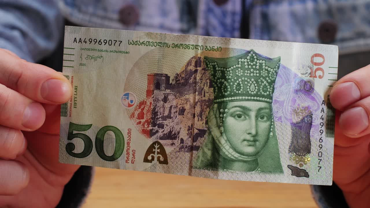 Five Georgian lari banknotes close-up. Universal currency converter GEL Central Bank. 5 lari paper money macro. Economy, financial and banking concept .