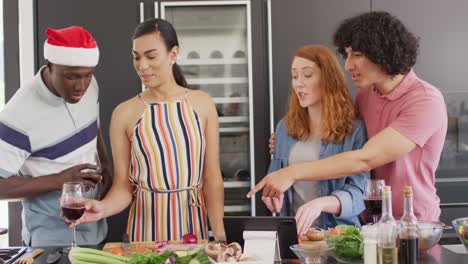 happy group of diverse friends cooking dinner in kitchen together