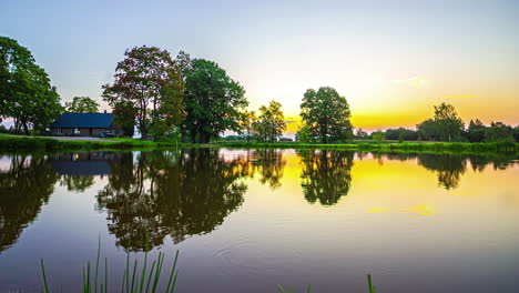 Surreal-Timelapse-of-a-Morning-Sunrise-Over-a-Clear-Calm-Lake-in-Europe