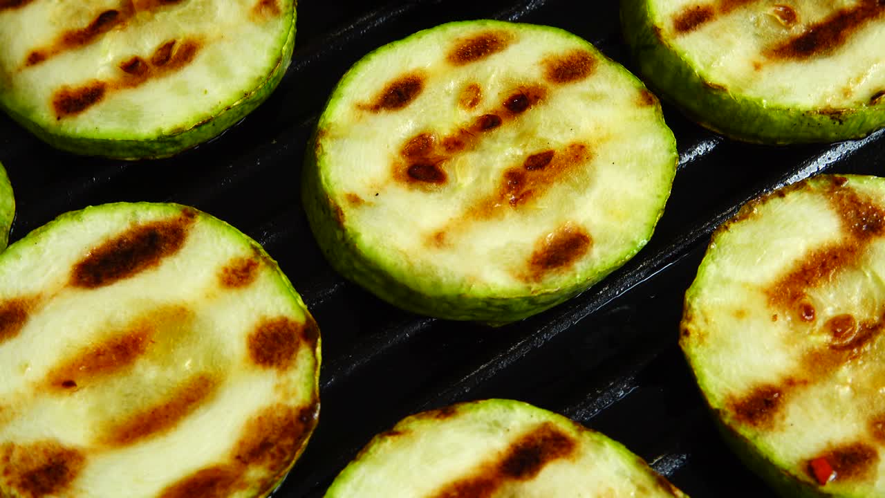 긴 zucchini 조각은 그릴 팬에 회전합니다.
